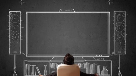 Young businessman sitting and enjoying home cinema system sketched on a chalkboard